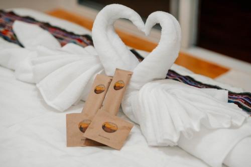 two swans made out of towels on a bed at บ้านพักภูมา 
