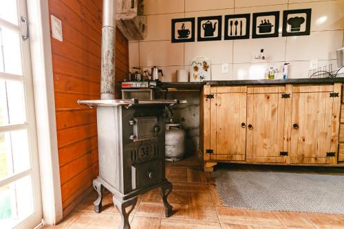 a kitchen with a wood stove in a room at Pousada recanto entre Rios Casa Vó Silvina in Urubici