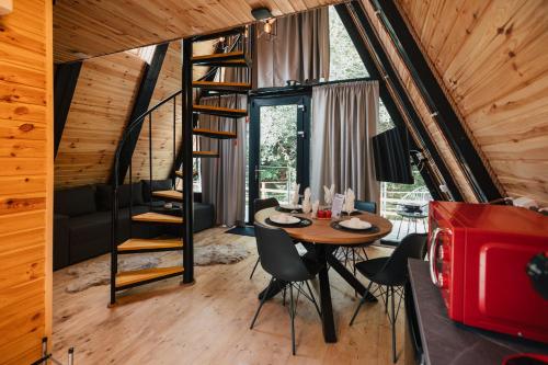 une chambre avec une table et des chaises et un escalier en colimaçon dans l'établissement Campulung Chalets, à Bughea de Sus