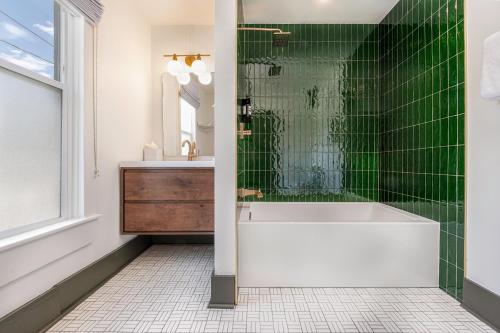 a bathroom with a white tub and green tiles at The Rochester Hotel in Durango