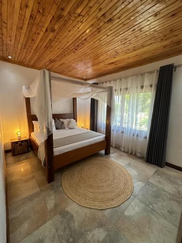 a bedroom with a bed with a wooden ceiling at Jumba paradise in Mtwapa