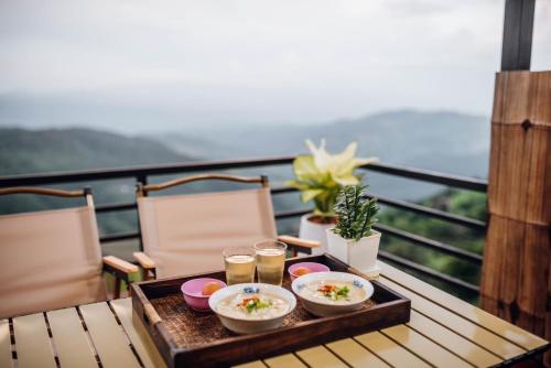 a tray of food on a table with drinks on a balcony at บ้านพักภูมา 