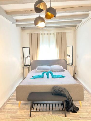 a bedroom with a large bed with a blanket on it at Maison Cosy , parking gratuit , 5 min aux Auxerre in Auxerre