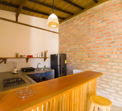 a kitchen with a counter and a brick wall at La Floristería in Palomino