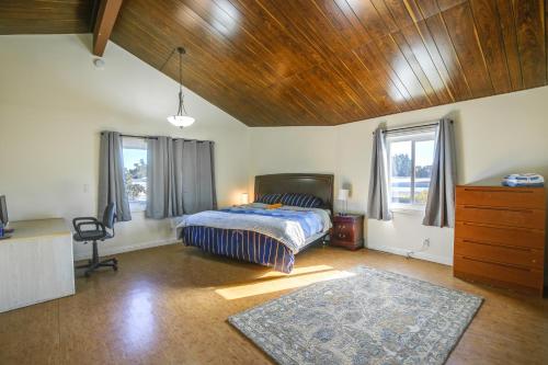 a bedroom with a bed and a desk and windows at Pet-Friendly Home about 5 Mi to Knotts Berry Farm! in Lakewood