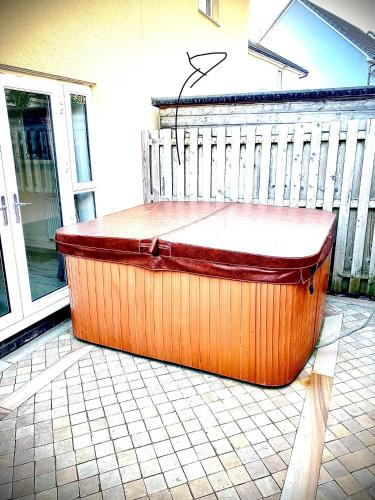 een grote hot tub op een patio bij Las Olas ~ Entire home with hot tub in Tythegston