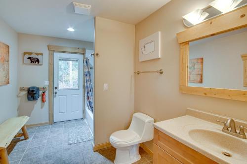 a bathroom with a toilet and a sink and a mirror at 1 Mi to Lake Easton Family Cabin with Deck! in Cabin Creek