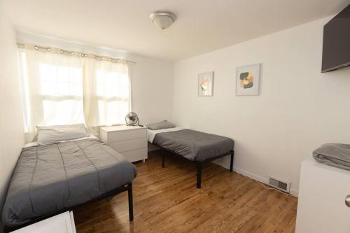 - une chambre avec 2 lits et une fenêtre dans l'établissement Mins close to Yale University/2Bedrooms/FastWifi, à Hamden