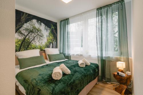 ein Schlafzimmer mit einem Bett mit Handtüchern darauf in der Unterkunft Modernes 2-Zimmer Themen-Apartment "Frankenwald" im Zentrum in Bayreuth