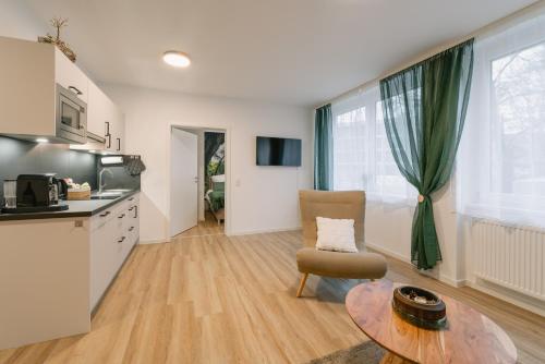 a kitchen and a living room with a table at Modernes 2-Zimmer Themen-Apartment im Zentrum in Bayreuth