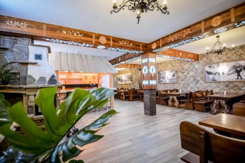 een restaurant met tafels en stoelen en een plant bij Czarna Turnia Villa w Zakopanem in Zakopane