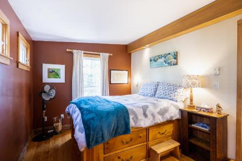 Un dormitorio con una cama grande y una ventana en Quiet Riverside Retreat with 2 Fireplaces, en Petite Rivière Bridge