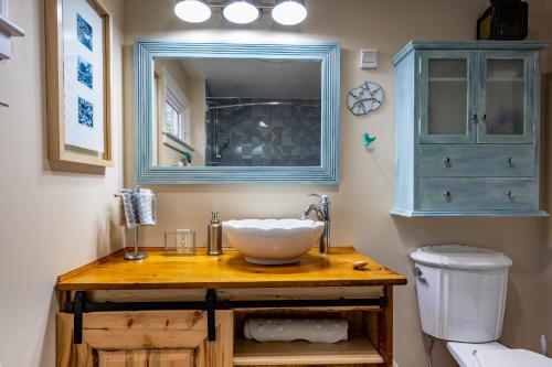 a bathroom with a sink and a mirror and a toilet at Quiet Riverside Retreat with 2 Fireplaces in Petite Rivière Bridge