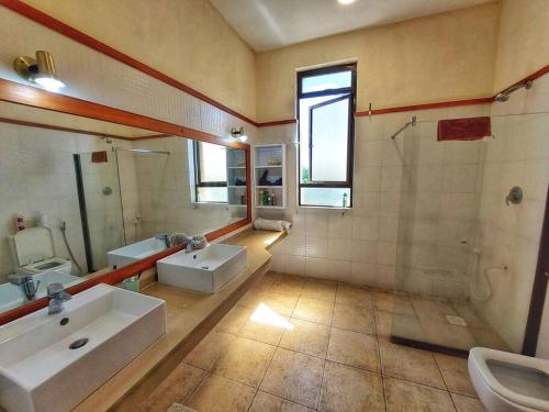 a large bathroom with two sinks and a shower at Breathtaking Ocean view apartment in Kikambala in Mombasa