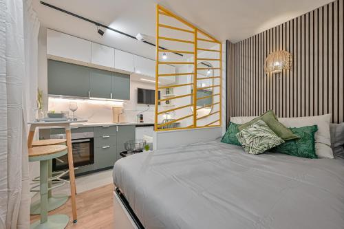 a bedroom with a bed and a desk and a kitchen at Joli Paris-Hyper centre in Paris