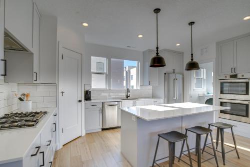 a kitchen with white cabinets and a island with stools at Modern Downtown Provo Townhome with Balcony! in Provo