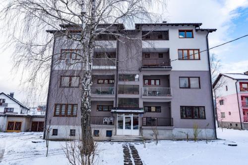 an apartment building in the snow with a tree at Pale Green in Pale
