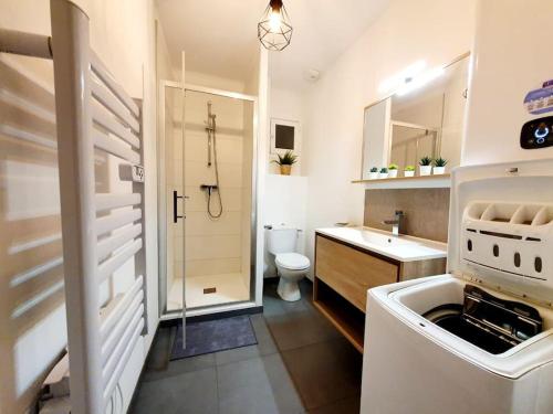 a white bathroom with a sink and a toilet at Le Cosy Paradis par Madame Conciergerie in Bruz