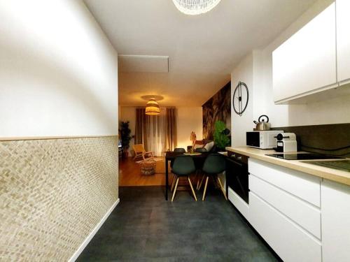 a kitchen with a table and chairs in a room at Le Cosy Paradis par Madame Conciergerie in Bruz