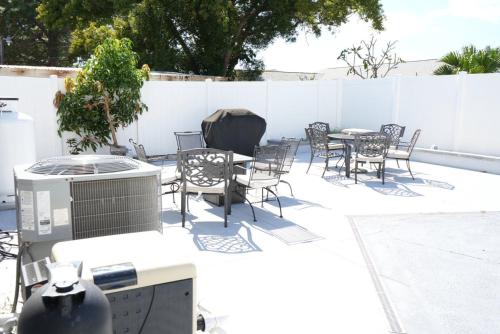 a patio with tables and chairs and a fence at Hosting 1 in Tampa