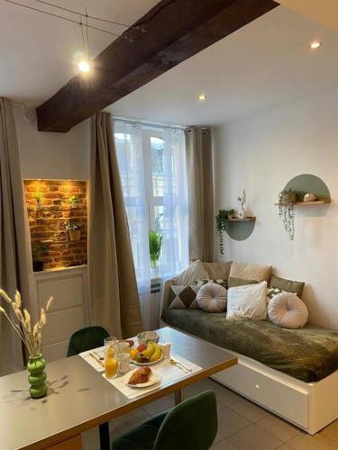 un salon avec un canapé et une table dans l'établissement Le Central - Parking Privé, à Douai