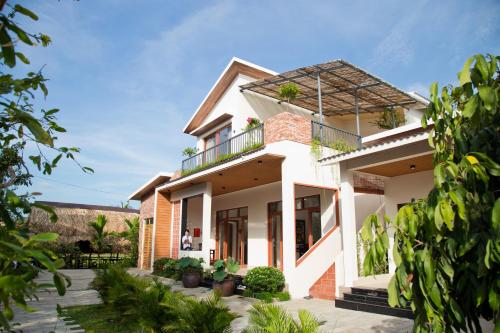 a white house with a balcony at Sông Mê Home in Vĩnh Long