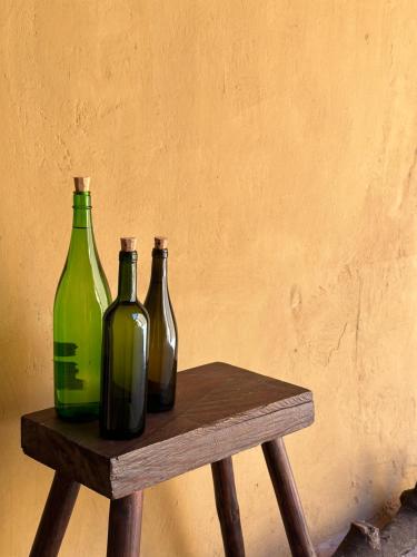 tres botellas de vidrio sentadas en una mesa de madera en CASA PENUMBRA- Centro Oaxaca en Oaxaca de Juárez