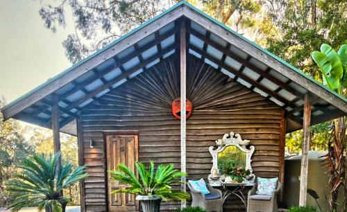 a small wooden cabin with a table and a door at Rainy Hill Retreat - The Cottage in Cockatoo