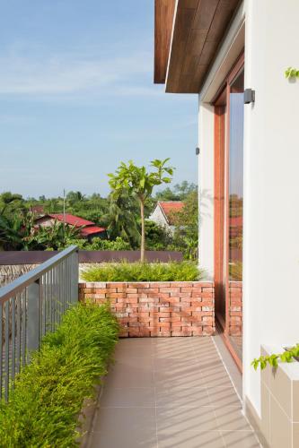 a balcony of a house with a brick wall at Sông Mê Home in Vĩnh Long