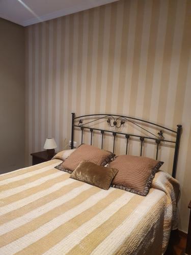 a bed with two pillows on it in a bedroom at Casco histórico- Vivienda de 2 habitaciones con parking in Oviedo