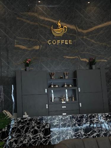 a black cabinet with a coffee sign on a wall at فيوبارك للشقق المخدومة1 in Al Hofuf