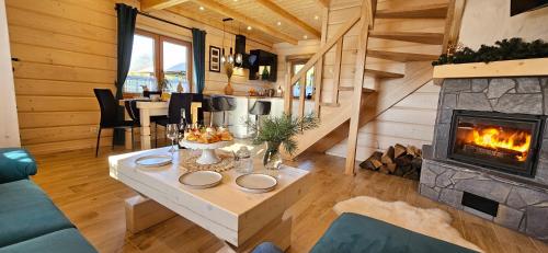 a living room with a fireplace in a log cabin at Bieszczadzkie Chaty in Polańczyk