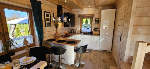a kitchen in a tiny house with a table and chairs at Bieszczadzkie Chaty in Polańczyk