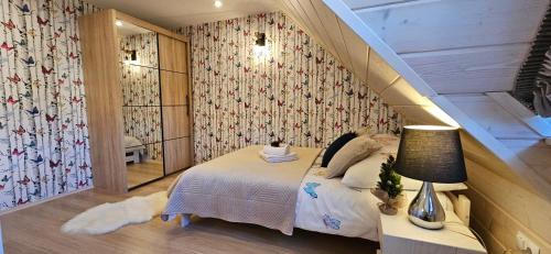 a small bedroom with a bed and a staircase at Bieszczadzkie Chaty in Polańczyk