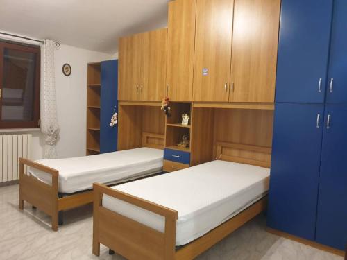 FaggianoにあるAppartamento L'Oleandro B&Bのベッドルーム(ベッド2台、木製キャビネット付)