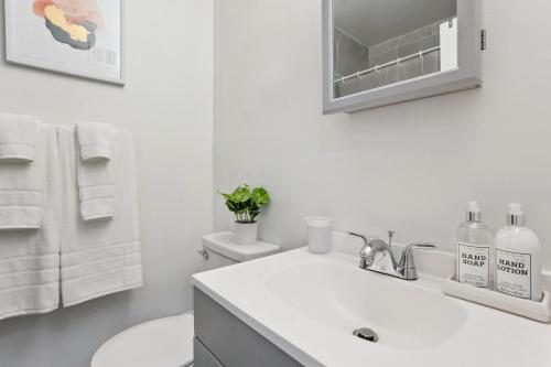 a white bathroom with a sink and a toilet at Philadelphia Vacation Rental Near Public Transit! in Philadelphia
