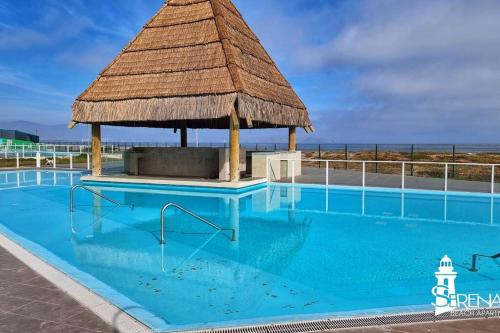 a large swimming pool with a gazebo at Serena's Beach Apartment in La Serena