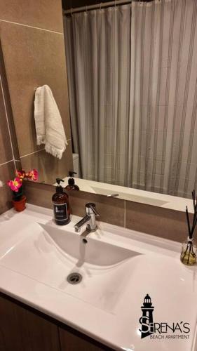 a white sink in a bathroom with a mirror at Serena's Beach Apartment in La Serena