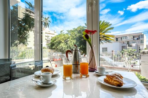 una mesa con dos platos de comida y dos vasos de zumo de naranja en B&B Cumpari Turiddu, en Siracusa