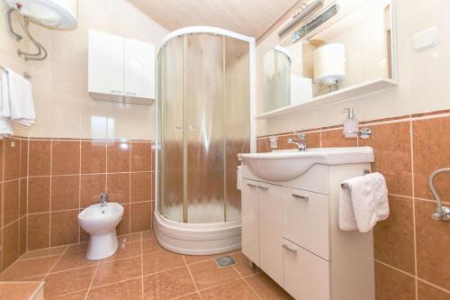 a bathroom with a shower and a sink and a toilet at House Dinko in Bol