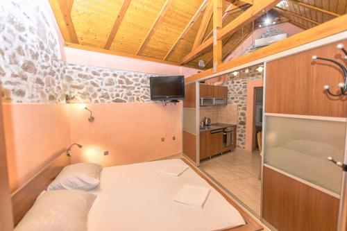 a small room with a bed and a kitchen at House Dinko in Bol