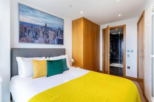ein Schlafzimmer mit einem großen Bett und einer gelben Decke in der Unterkunft Panoramic balcony luxury condo in London