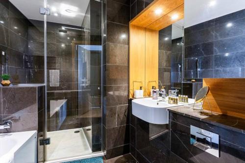 a bathroom with two sinks and a shower at Panoramic balcony luxury condo in London