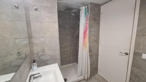 een badkamer met een douche, een wastafel en een bad bij Apartamento Bahia III in Empuriabrava