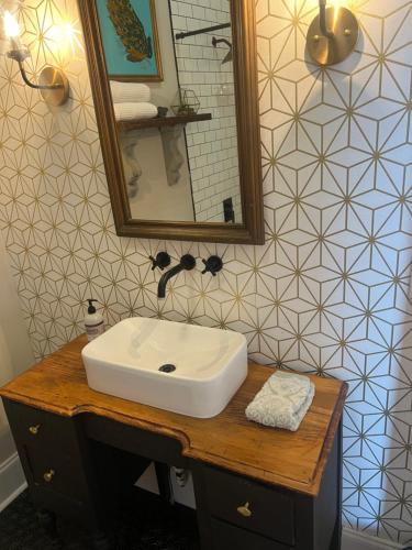 een badkamer met een witte wastafel en een spiegel bij Masseys on Grove Unit B in Vicksburg