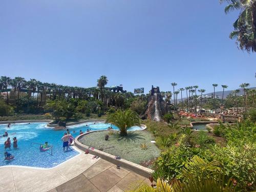 un gruppo di persone in una piscina in un parco a tema di Apt. Faraj a Playa de las Americas
