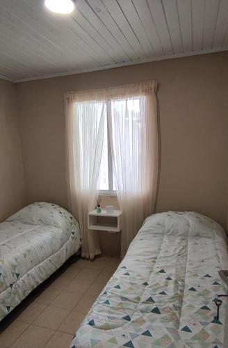 um quarto com 2 camas e uma janela em La Rosadita House em Jardín América