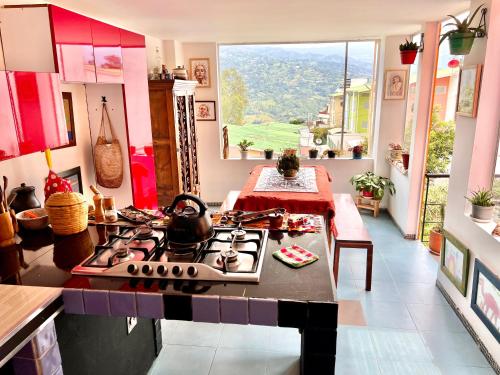 a kitchen with a stove and a table and a window at B&B - Trekking y Senderismo in Choachí