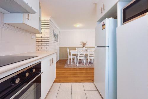 a kitchen with a white refrigerator and a table at Seaside Haven, 3-62 Tomaree Rd - Wi-Fi and perfect for families in Shoal Bay