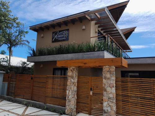 a house with a balcony on top of it at Pousada Kirana in Praia do Rosa